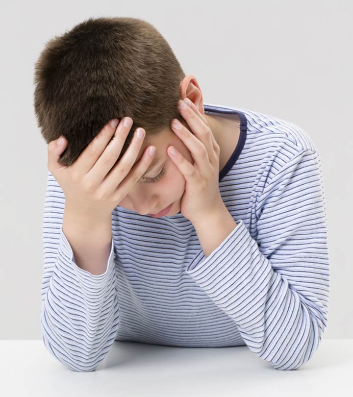 Child Holding Their Head In Pain, Representing A Headache