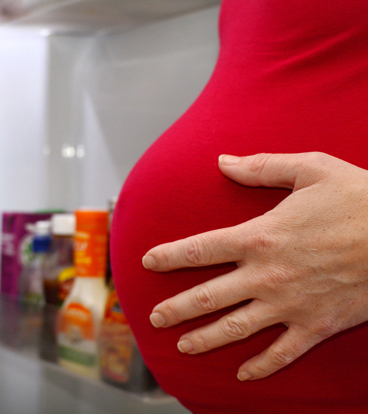 Pregnant woman experiencing hunger pangs and holding her stomach