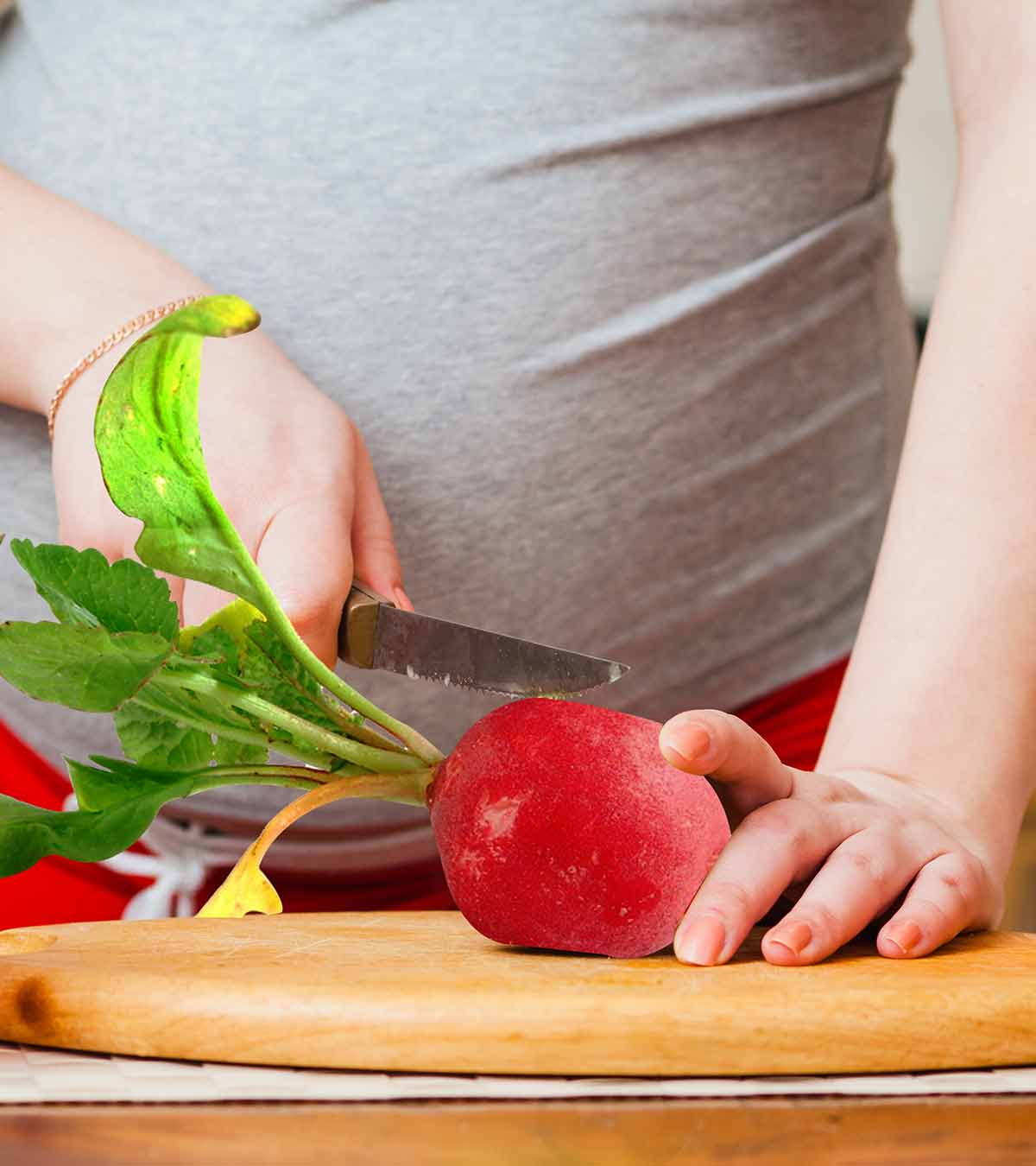 A pregnant lady cutting radish