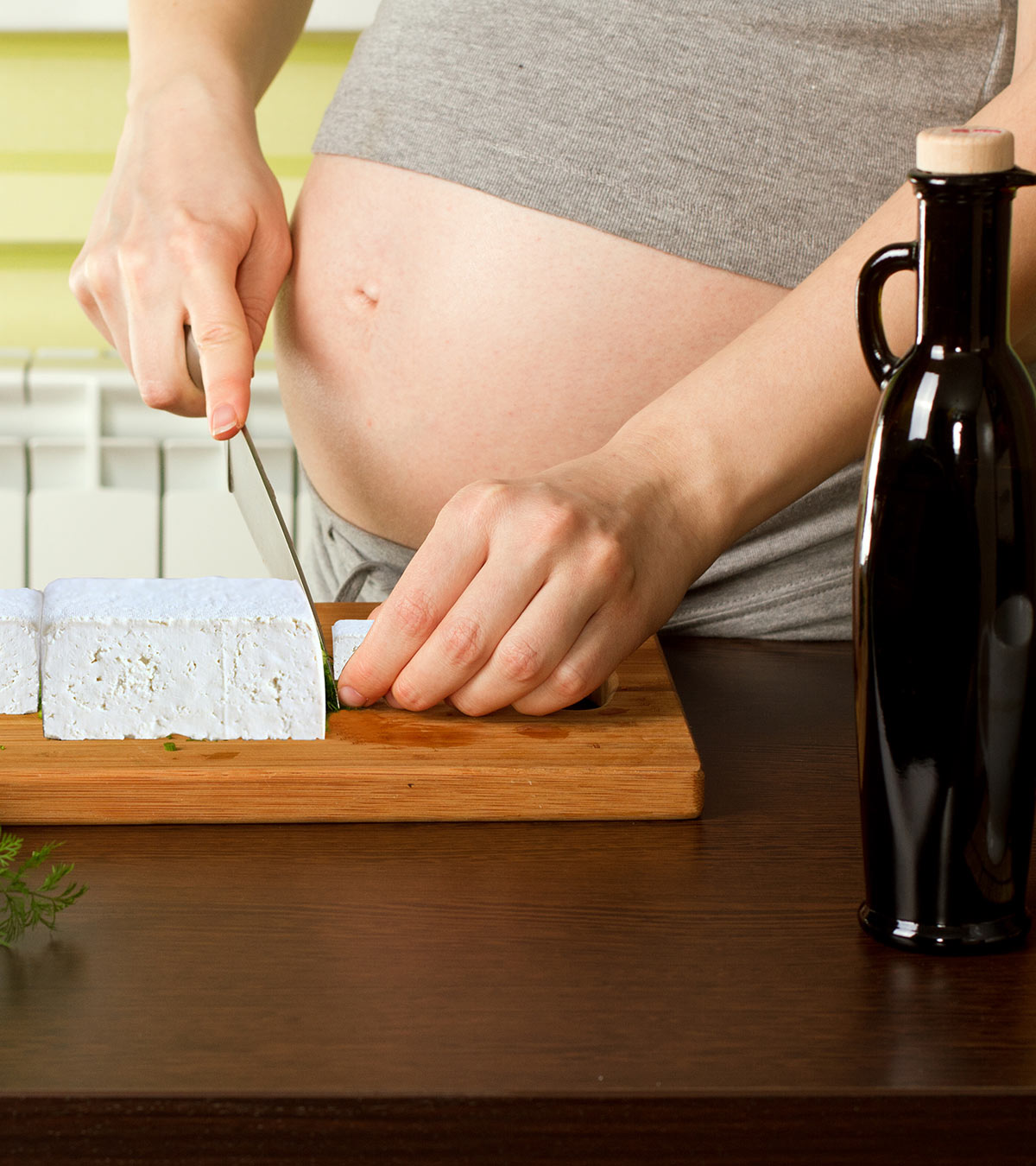 A pregnant lady cutting tofu