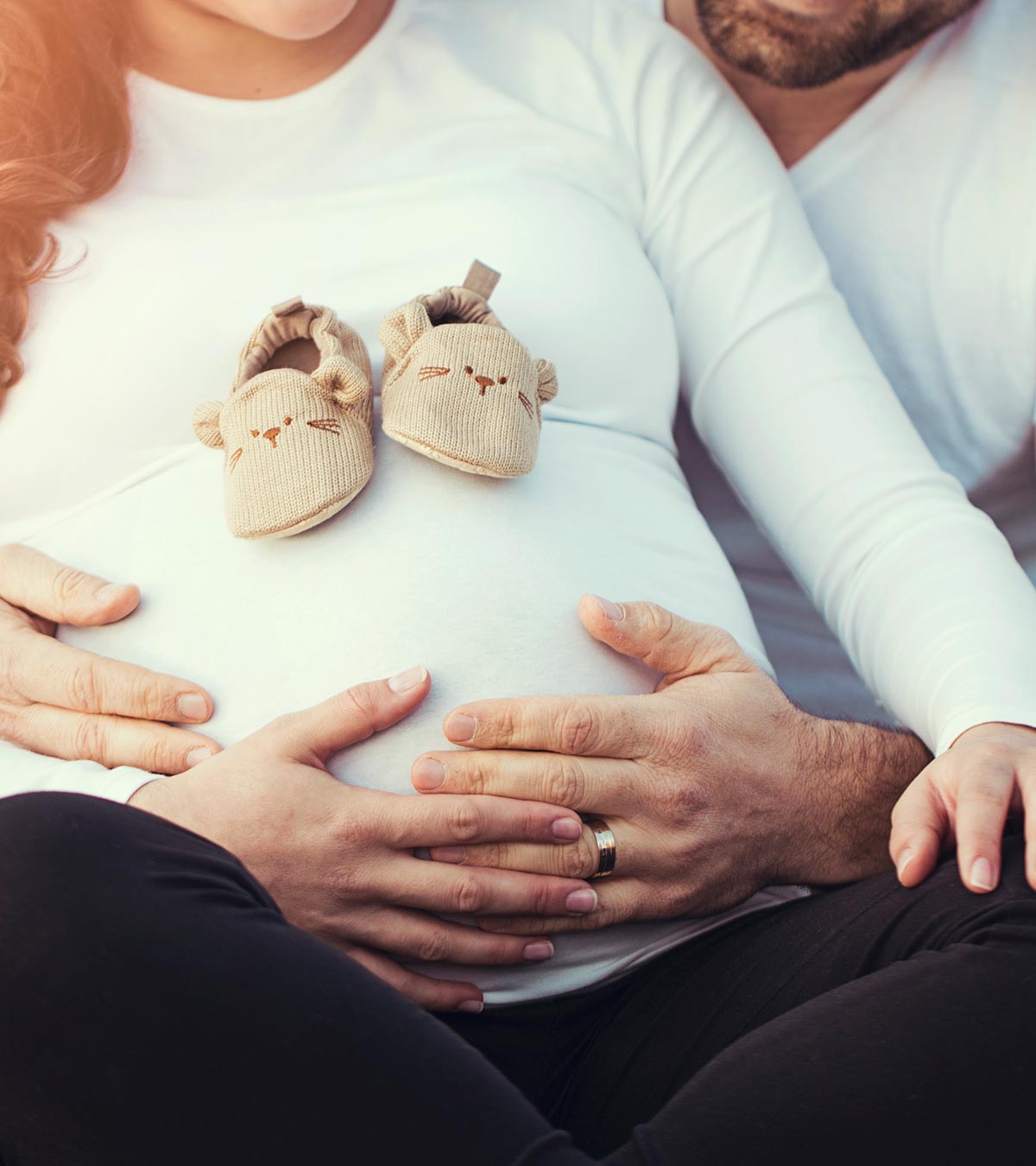 A guy holds his pregnant wife